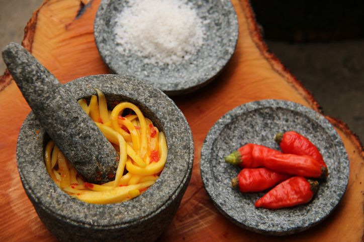 A popular Indonesian condiment of red chili peppers and tomato paste in traditional mortar and pestle is sambal ulek