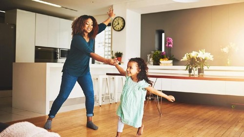 Excited female raising fist and cheering while watching sport on mobile phone in campus