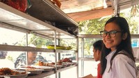 Tanpa gengsi, Indah jajan makanan di warteg. Ia bersiap memilih makanan yang akan jadi santapannya. Senyum manis mengembang di wajahnya. Foto: instagram @indahpermatas