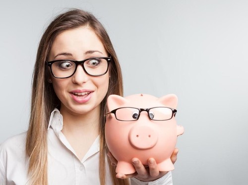 Beautiful young woman at coffee shop holding a green tea cup looking away and smiling. Female having green tea at coffee shop.