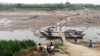 Kondisi hamparan sungai yang kering dan beberapa perahu kayu bersandar di pinggiran.