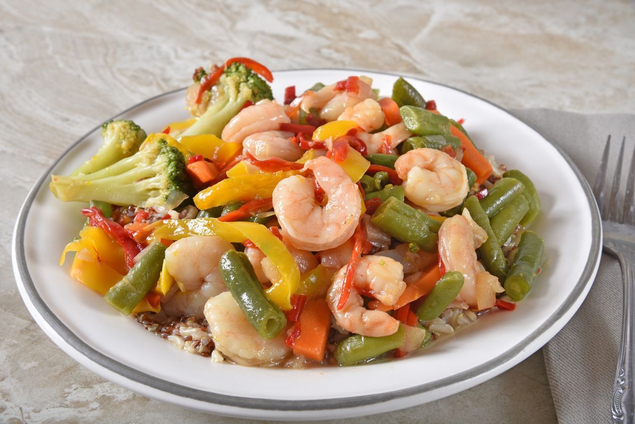 High angle view of a bowl of shrimp stir fry with green beans, broccoli and bell peppers