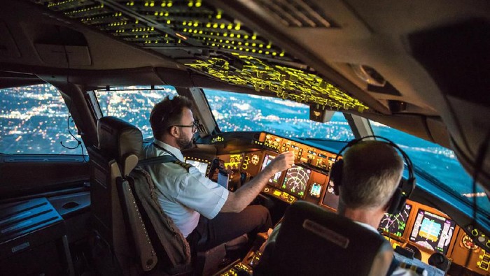 Two pilots at work during departure of Dallas Fort Worth Airport in United States of America. The view from the flight deck with high workload the beginning night through the wind shield