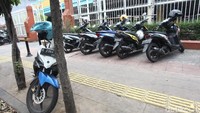 Tak hanya mobil, motor pun leluasa parkir di trotoar.