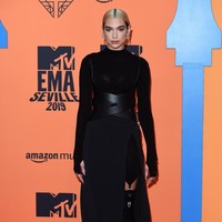 MTV Europe Music Awards 2019 berlangsung di Seville, Spanyol, Minggu (3/11/2019). Hadir sebagai penampil, Dua Lipa memilih busana serba hitam untuk sesi karpet merah. Terusan tersebut dilengkapi korset kulit serta stocking bergaya BDSM yang seksi. (Foto: Getty Images)