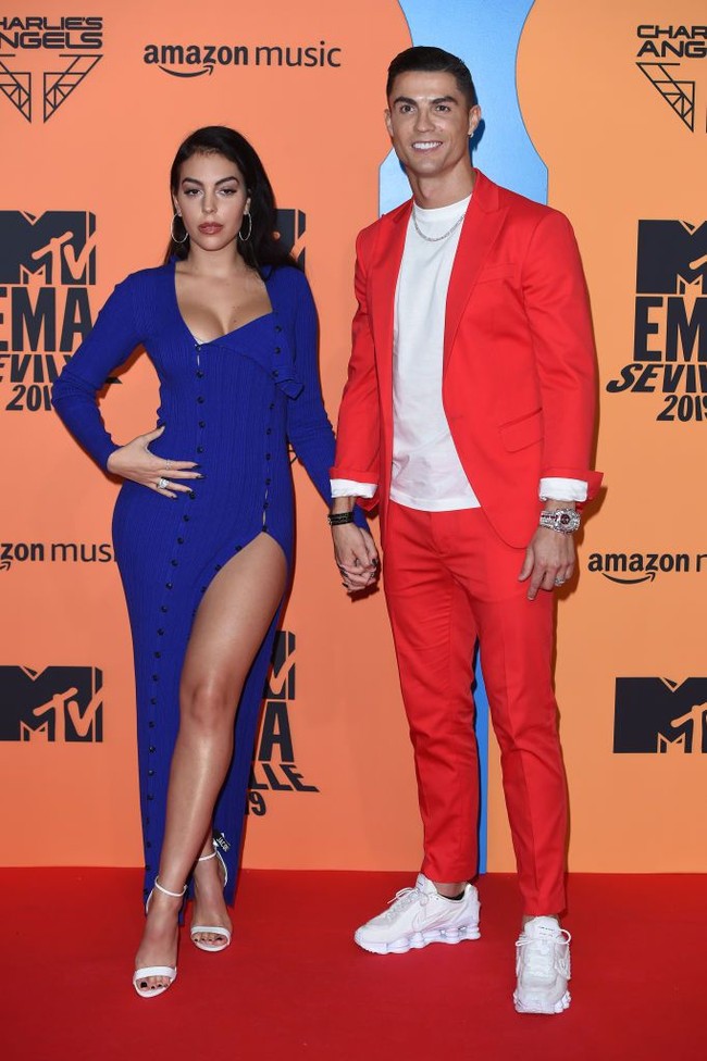 MTV EMAs 2019 juga dihadiri pesepakbola Cristiano Ronaldo dan kekasihnya, Georgia Rodriguez. Untuk ajang penghargaan musik tersebut, pemain Juventus itu mengandalkan setelan merah yang dipadu kaus dan sneakers putih. Tidak ketinggalan sebuah jam tangan sebagai statement. Sementara itu, Georgia hadir dalam balutan gaun biru seksi dengan belahan rok yang tinggi. (Foto: Getty Images)