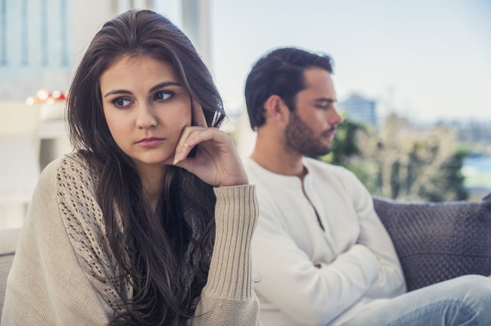 zodiak Young woman looking at bills while sitting on floor managing home budget