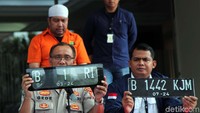 Polisi menunjukan pelat nomor palsu B 1 RI.