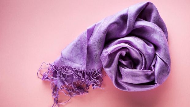 Silk scarf on a pink background, top view