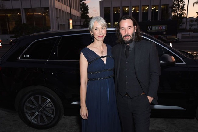 Untuk acara tersebut, Keanu yang kini berwajah berewokan tampak gagah dalam balutan setelan hitam. Sementara Alexandra memilih gaun biru navy bersiluet empire yang dihiasi lilitan tiga sabuk berdetail embellishment. (Foto: Getty Images)
