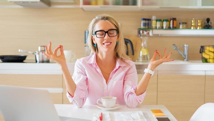 Young woman looking at bills while sitting on floor managing home budget