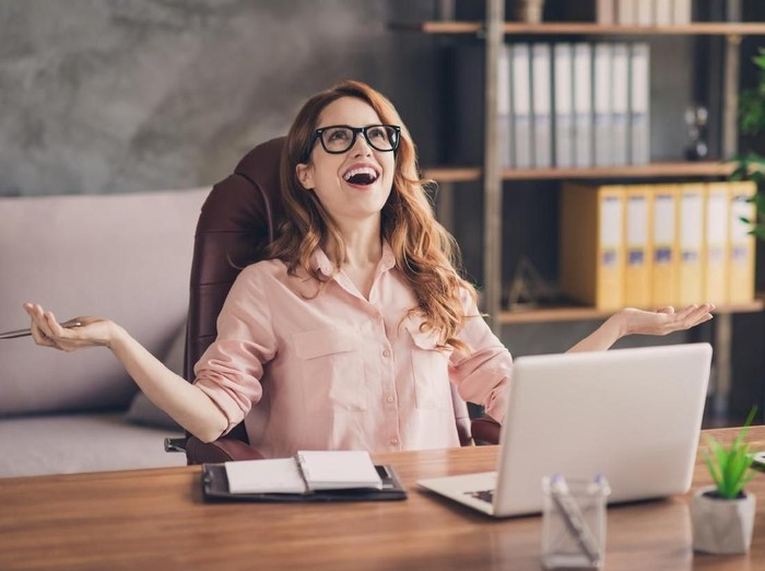 Close up photo beautiful she her business lady hand arm head raised up laugh laughter big salary income earnings genius startup notebook table sit office chair wearing specs formal-wear shirt.