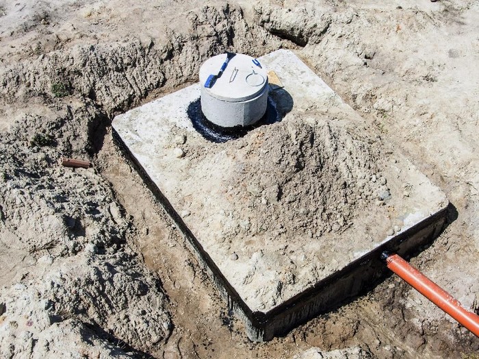 The partially removed plastic cover of a septic tank with the safety cover visible.