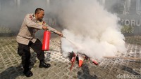 Polisi berusaha memadamkan traffic cone yang terbakar di depan KPK.