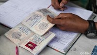 Seorang prajurit tengah memeriksa identitas seorang warga yang melintas di kawasan perbatasan Indonesia-Malaysia.