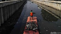 Petugas Unit Pelaksana Kebersihan (UPK) Badan Air Dinas Lingkungan Hidup DKI Jakarta membersihkan Kali Item dari sampah, Rabu (6/11/2019).