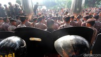 Massa GMBI kemudian mendekat ke area teras gedung KPK. Mereka terlihat naik ke atas pagar gedung KPK.