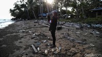 Seorang pengunjung sedang memotret pemandangan alam di Pantai Batu Lamampu yang berserakkan sampah plastik.