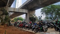 Selain terparkir di pinggir jalan, nampak pula sejumlah kendaraan berjejer rapi terparkir di lahan kosong yang berada di bawah JLNT Kuningan-Tanah Abang, Jakarta.