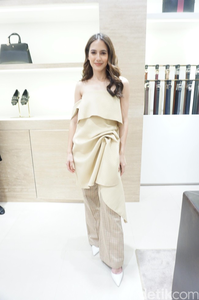 Atasan coklat pastel berpotongan struktural menjadi andalan Pevita Pierce. Ia lalu memaksimalkan gayanya dengan celana palazzo motif kotak dan pointed heels putih. (Foto: Daniel Ngantung/Wolipop)