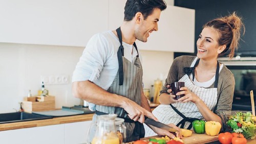 Lovely couple making salad in the kitchen.