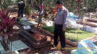 Polisi mengecek kondisi makam yang dibongkar secara misterius. Pool/Polsek Cikatomas.