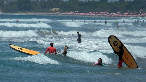 Wisatawan mancanegara bermain selancar di Pantai Kuta, Badung, Bali, Jumat (8/11/2019).  Badan Meteorologi Klimatologi dan Geofisika (BMKG) mengeluarkan peringatan dini untuk mewaspadai potensi gelombang tinggi mencapai 2 meter di Selat Bali, Selat Badung, Selat Lombok dan Samudera Hindia selatan Bali akibat perubahan cuaca. ANTARA FOTO/Nyoman Hendra Wibowo/nym/ama.