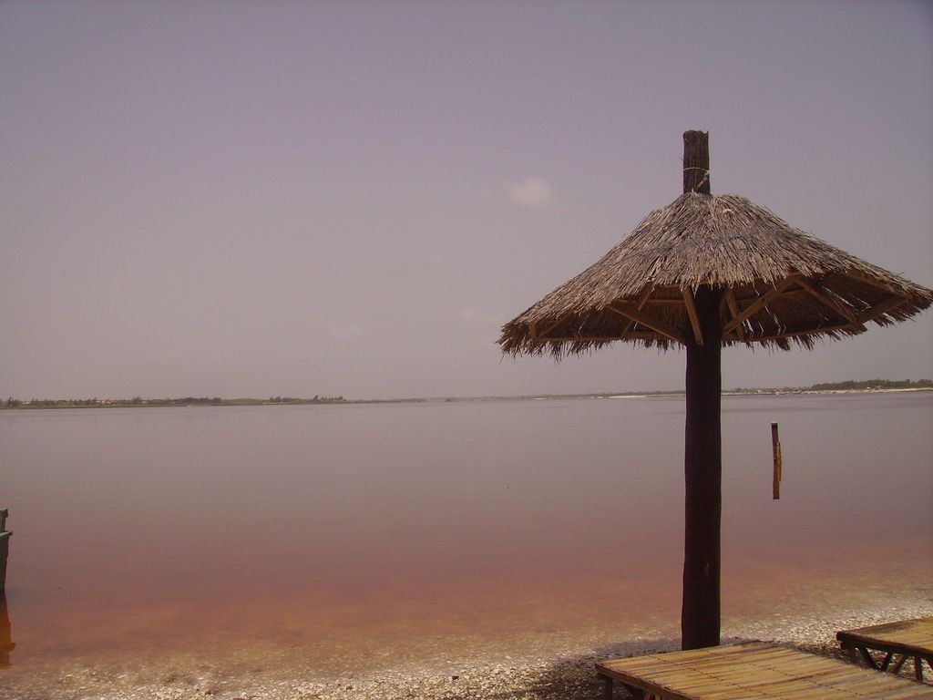 Lac Rose, Pink Lake, is in the greater Dakar region of Senegal. The color is due to algae that thrives in salt water. The mounds are the remains of activity used to mine the salt from the lake and dry it on shore. The small row boats are used to transfer the salt from containers filled out in the lake to shore for evaporation
