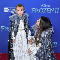 Gaun putih motif floral dengan lengan berbentuk lonceng menonjolkan aura feminin penyanyi Lose You To Love Me ini. Untuk memberi kesan salju dan es, ia memadukannya dengan outer wear beraksen bulu-bulu dengan detail atraktif di bagian bahu. Begitu pun Gracie yang tampil kembaran dengan sang kakak. Foto: Amy Sussman/Getty Images