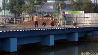 Sejumlah pekerja sedang menyelesaikan pembangunan jembatan yang berada di atas aliran Sungai Kalimalang di kawasan Tambun Selatan, Kabupaten Bekasi, Jumat (8/11/2019).