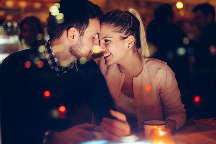 996232616 Romantic young couple dating in pub at night