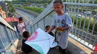 Setiap sore, sejumlah anak-anak ini menghabiskan waktu bermain layang-layang di JPO.
