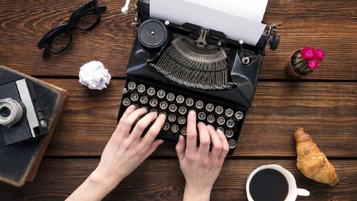 Crop person using typewriter