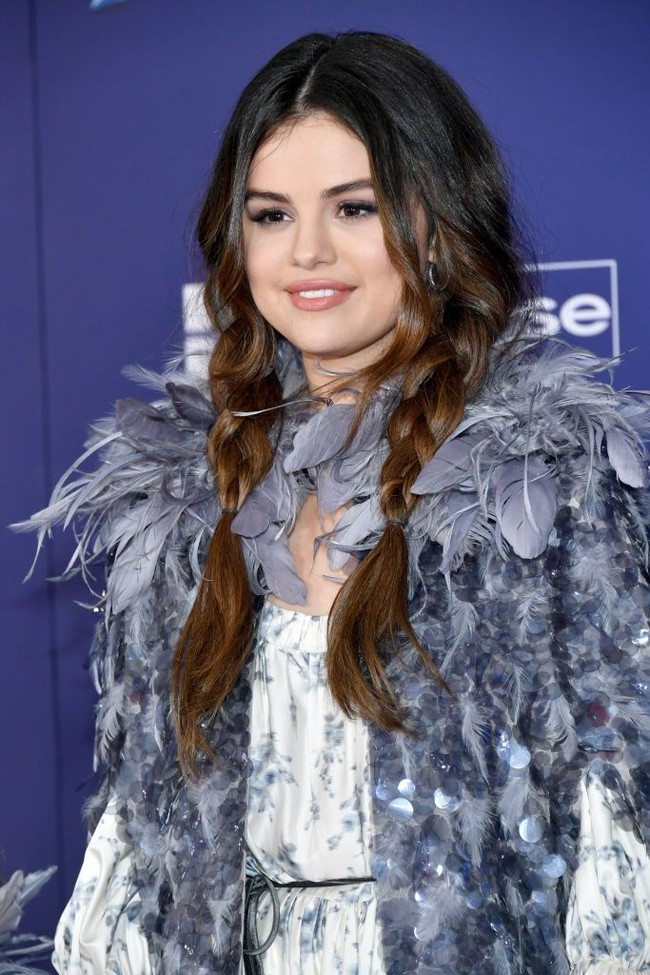 Selena menata rambutnya seperti Anna, karakter putri dan adik dari Ratu Elsa. Rambut dikepang secara loose dan menyisakan poni depan yang membingkai wajah cantik Selena, menambah aura feminin dan ayu. Foto: Amy Sussman/Getty Images