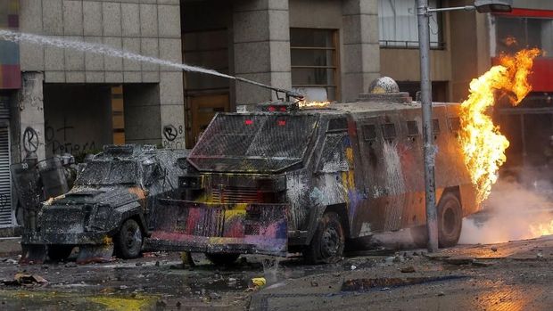 Polisi antihuru-hara bentrok dengan demonstran yang melakukan pembakaran di Santiago