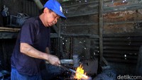 Bengkel pandai besi milik Enen Junaedi (84) yang berada di Kampung Balekembang, Desa Sukamaju, Kecamatan Majalaya, Kabupaten Bandung, Jawa Barat, nampak sibuk. Seorang pandai besi tengah membuat sebilah golok, Sabtu (9/11/2019).