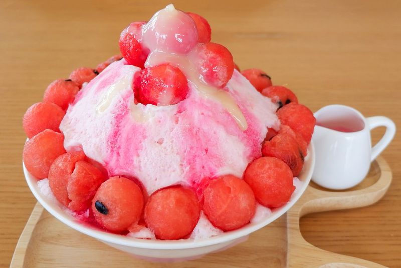 Shaved ice dessert served with mango sliced,  whipped cream and vanilla ice cream. Sweet dessert in Korean style. Local name, Bingsu.