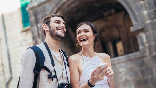 Couple in love, enjoying the summer time by the sea.Joyful girl piggybacking on young boyfriend having fun.