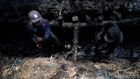 Petugas Sudin Tata Air DKI Jakarta alias Pasukan Biru nyemplung ke saluran air untuk membersihkan lumpur, Senin (11/11/2019).