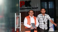 Supendi meninggalkan gedung KPK dengan menutupi tangannya yang diborgol dengan buku.