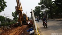 Dengan alat berat para pekerja membangun tiang pancang proyek pembanguan simpang tak sebidang (STS) Flyover Lenteng Agung-IISIP.