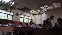 Atap ruang kelas di SDN Mulyorejo 05 nampak jebol dan belum diperbaiki. Meski begitu para siswa tetap hadir untuk belajar di ruang kelas tersebut. ANTARA FOTO/Seno.