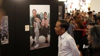 Jokowi melihat foto-foto yang dipamerkan.