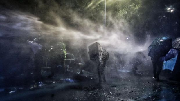 Demonstran Hong Kong berlindung dari tembakan meriam air