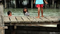 Tinggal di kawasan permukiman nelayan yang dekat dengan laut membuat anak-anak tersebut terbiasa berenang maupun bermain air.