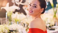 Berbalut dress berwarna merah menyala, Jolene nampak anggun duduk di depan meja makan yang dihiasi bunga berwarna putih. Foto: Instagram @joleneemarie