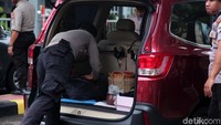 Petugas memeriksa setiap barang yang ada di dalam mobil.