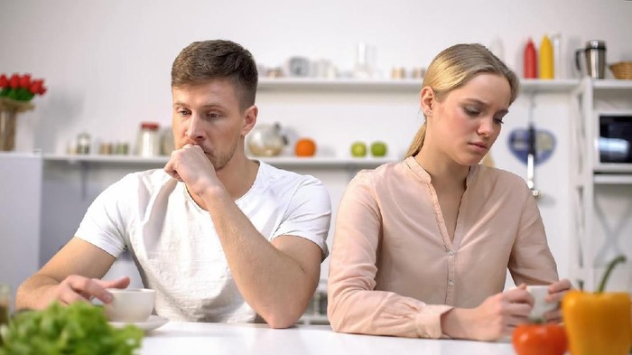 Upset couple ignoring each other at kitchen, relationship difficulties, quarrel