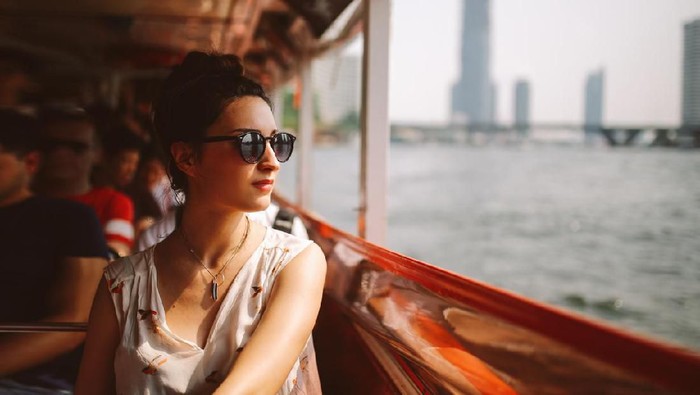 Frustrated young woman suffering from the headache while sitting on the sofa at home