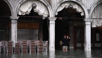 Turis yang datang berkunjung ke Venesia saat banjir pun tak lupa mengabadikan momen tersebut lewat kamera mereka (Marco Bertorello/AFP)